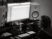 Focused audio engineer mixing tracks in a professional recording studio with headphones.